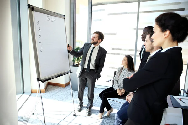 Vrolijke zakenman nieuw zakelijk project bespreken met de leden van zijn team — Stockfoto