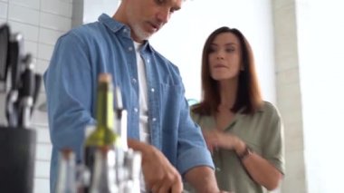 Mutlu çift evde birlikte yemek pişiriyor. Evli çift ev mutfağında flört ediyor.