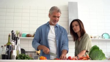 Mutlu çift evde birlikte yemek pişiriyor. Evli çift ev mutfağında flört ediyor.