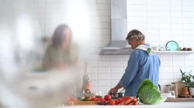 Mutlu çift evde birlikte yemek pişiriyor. Evli çift ev mutfağında flört ediyor.