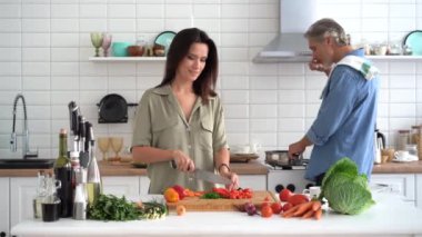 Mutlu çift evde birlikte yemek pişiriyor. Evli çift ev mutfağında flört ediyor.