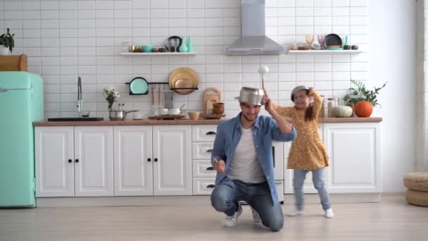 Father and daughter having fun together in light modern kitchen playing fight — Stock Video