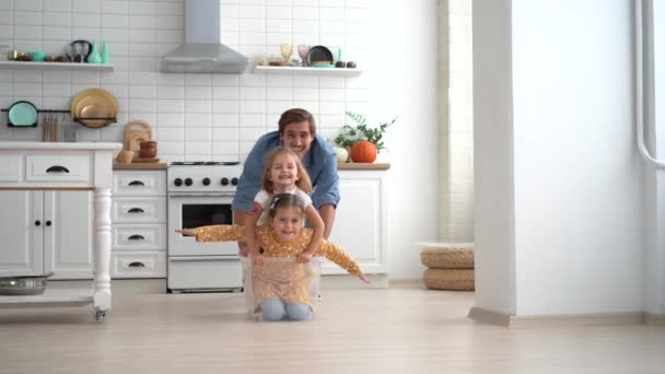 Glücklicher Vater führt Push-Box mit kleinen süßen Kindern Töchter fahren drinnen — Stockvideo