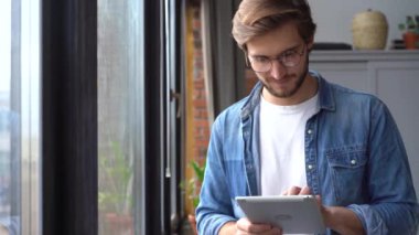 Ofiste dijital tablet kullanan genç profesyonel işçi.