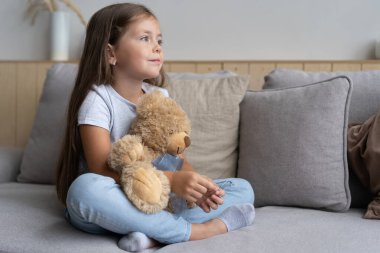 Pozitif gülümseyen kız kanepede yatıyor.