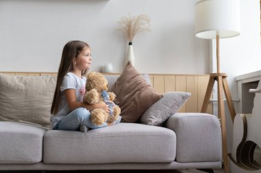 Pozitif gülümseyen kız kanepede yatıyor.