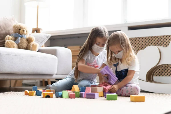 Kids children wearing mask for protect Covid-19, playing block toys in playroom. — Photo