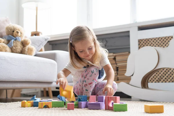 Wenig süß mädchen spielzeug block im spielzimmer bei zuhause. — Stockfoto