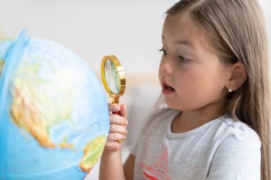 Eğitim ve okul konsepti. Çocuk kız küreyi işaret ediyor.