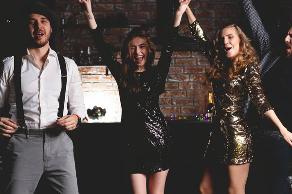 Dans etmeyi seviyorlar. Bir grup genç insan şampanya kadehleriyle dans ediyor ve mutlu görünüyorlar.. — Stok fotoğraf