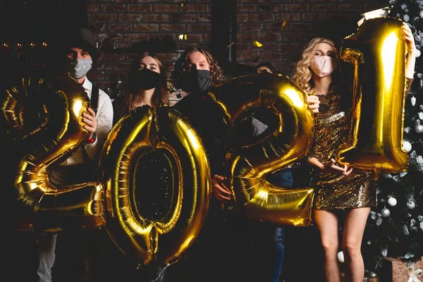 Fest, människor och nyårshelg koncept - kvinnor och män i skyddande medicinsk mask fira nya år kväll 2021 — Stockfoto