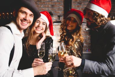 Yeni yıl partisinin tadını çıkarıyorum. Noel Baba şapkalı bir grup güzel genç dans ediyor ve mutlu görünüyorlar..