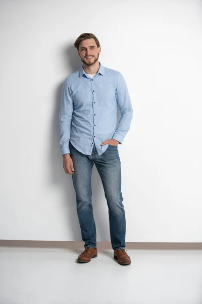 Full length studio portret van casual jongeman in jeans en shirt. Geïsoleerd op witte achtergrond. — Stockfoto