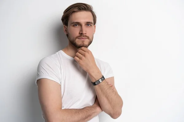 Retrato de um jovem inteligente em pé contra fundo branco. — Fotografia de Stock