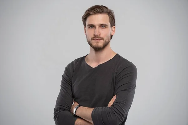 Portrait of a smart young man standing against grey background. — Stock Photo, Image