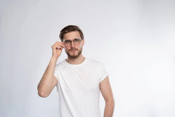 Портрет умного молодого человека в очках, стоящего на белом фоне. — стоковое фото