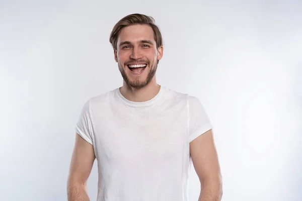 Σέξι χαμογελαστός όμορφος άντρας με λευκό μπλουζάκι απομονωμένος σε λευκό. — Φωτογραφία Αρχείου