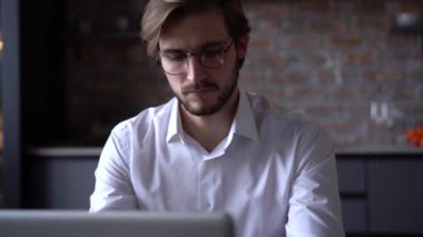 İşadamı odaklı girişimci dizüstü bilgisayarla araştırma yapıyor. Bilgisayarı kullanan genç profesyonel bir erkek ofis masasında oturuyor. Modern teknoloji not defteri üzerinde çalışan meşgul bir işçi..