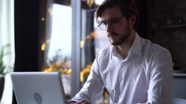 İşadamı odaklı girişimci dizüstü bilgisayarla araştırma yapıyor. Bilgisayarı kullanan genç profesyonel bir erkek ofis masasında oturuyor. Modern teknoloji not defteri üzerinde çalışan meşgul bir işçi..