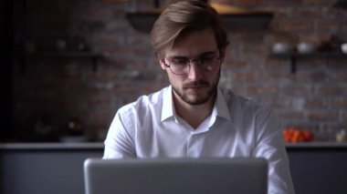 İşadamı odaklı girişimci dizüstü bilgisayarla araştırma yapıyor. Bilgisayarı kullanan genç profesyonel bir erkek ofis masasında oturuyor. Modern teknoloji not defteri üzerinde çalışan meşgul bir işçi..