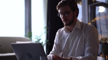 İşadamı odaklı girişimci dizüstü bilgisayarla araştırma yapıyor. Bilgisayarı kullanan genç profesyonel bir erkek ofis masasında oturuyor. Modern teknoloji not defteri üzerinde çalışan meşgul bir işçi..