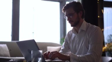 İşadamı odaklı girişimci dizüstü bilgisayarla araştırma yapıyor. Bilgisayarı kullanan genç profesyonel bir erkek ofis masasında oturuyor. Modern teknoloji not defteri üzerinde çalışan meşgul bir işçi..