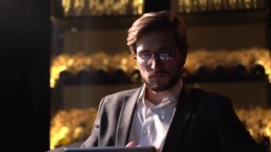 İş adamı internet sörfü yaparken dokunmatik ekranlı tablet bilgisayar yüzeyi kullanıyor. Çevrimiçi çalışma ya da metin mesajı için internet tableti kullanan kendine güvenen işadamı.