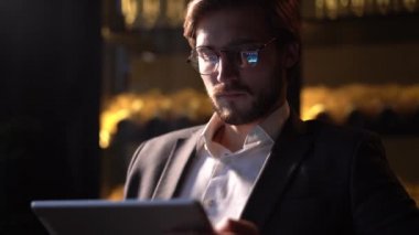 İş adamı internet sörfü yaparken dokunmatik ekranlı tablet bilgisayar yüzeyi kullanıyor. Çevrimiçi çalışma ya da metin mesajı için internet tableti kullanan kendine güvenen işadamı.