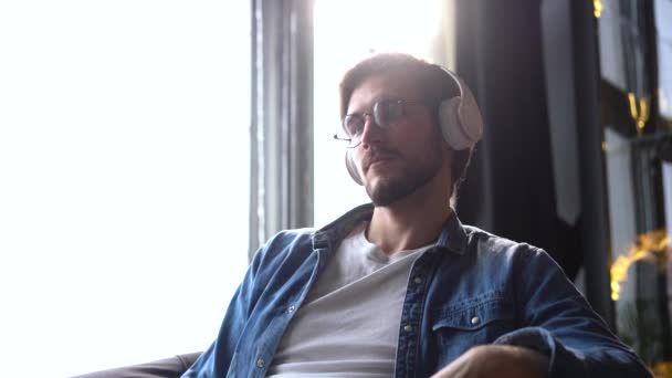 Uomo seduto sulla sedia e ascoltando podcast. Happy Healthy Stress Free Man Rilassarsi e ascoltare musica. Dipendente che si prende una pausa sul lavoro. Uomo d'affari Tempo libero in cuffia. — Video Stock