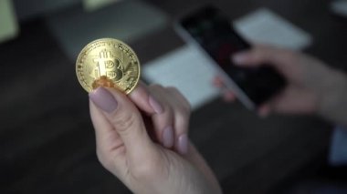 Akıllı telefon kullanan ve elinde para tutan bir kadın..