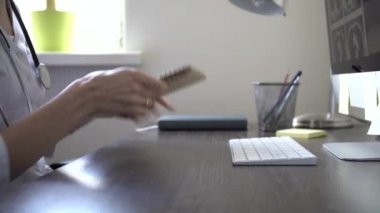 Boynunda steteskop olan kadın doktor hasta hastayla konuşmasını bitirdi.