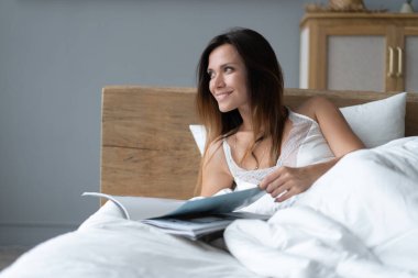 Zarif bir kadın evde yatıp günlük okuyor..