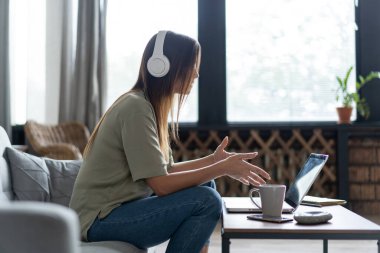 Evde internet işi. Laptop kullanan bir kadın evdeki görüntülü konuşma uygulaması aracılığıyla partneriyle konuşuyor.