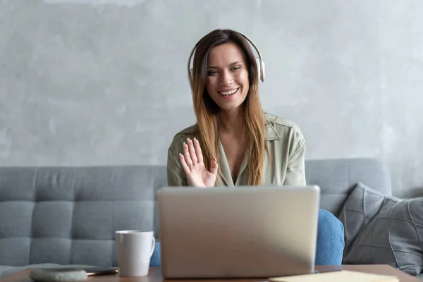 Online work at home. A woman using laptop she speaks with a partner through the video call chat application at home