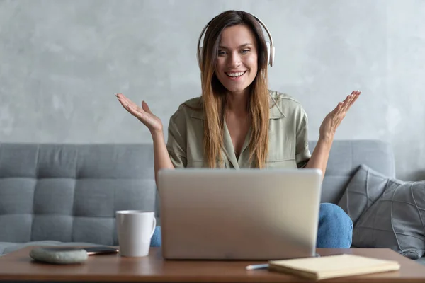 Trabajo en línea en casa. Una mujer que utiliza el ordenador portátil que habla con un compañero a través de la aplicación de chat de videollamadas en casa — Foto de Stock