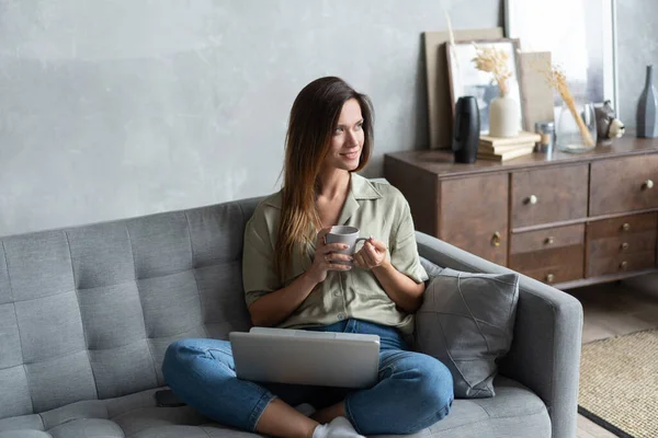 Femme utilisant un ordinateur portable dans son salon. Je travaille de chez moi en quarantaine. Distance sociale. — Photo