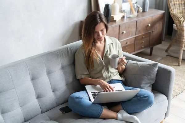 Femme utilisant un ordinateur portable dans son salon. Je travaille de chez moi en quarantaine. Distance sociale. — Photo