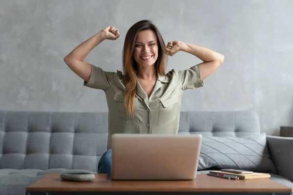 Jovem muito feliz sentar no sofá em casa triunfo receber e-mail agradável ou ler boas notícias no laptop on-line Imagens De Bancos De Imagens Sem Royalties