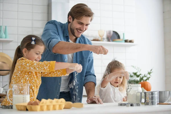 Sonriente padre e hijas hornear en la cocina y divertirse — Foto de Stock