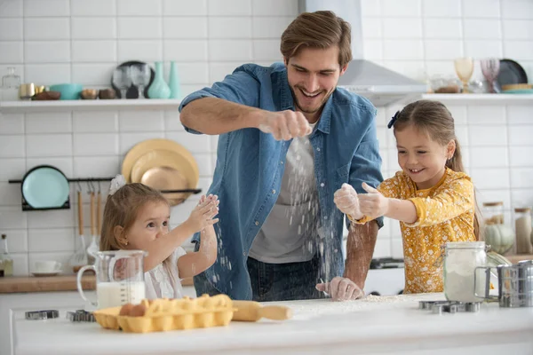 Sonriente padre e hijas hornear en la cocina y divertirse — Foto de Stock