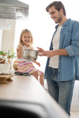 Baba 'ya mutfakta yemek pişirmesinde yardım eden kız..