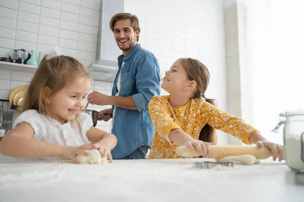 Sonriente padre e hijas hornear en la cocina y divertirse — Foto de Stock