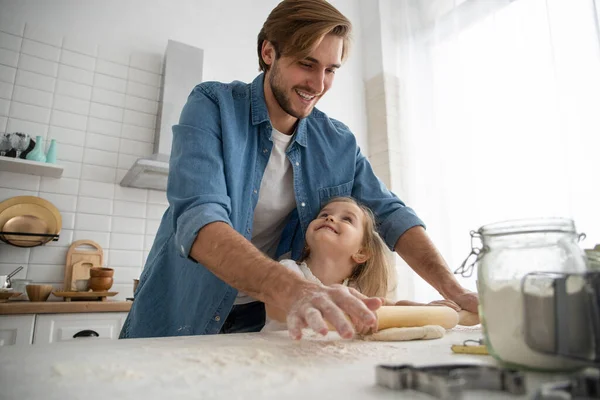 Cuidado joven caucásico padre y lindo poco preescolar hija hornear en cocina en casa juntos — Foto de Stock