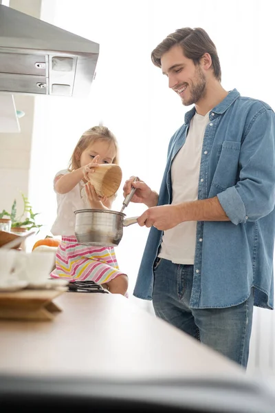 Hija ayudando a padre a cocinar comida en la cocina. — Foto de Stock