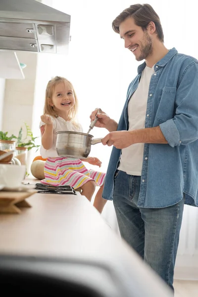 Hija ayudando a padre a cocinar comida en la cocina. — Foto de Stock