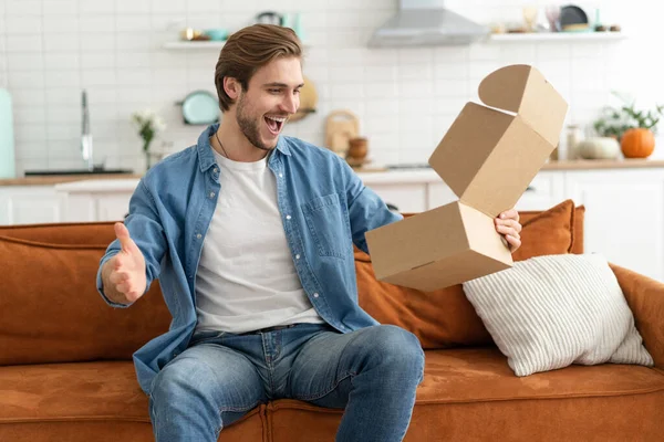 Happy man customer unpacking cardboard box receive open post mail delivery package