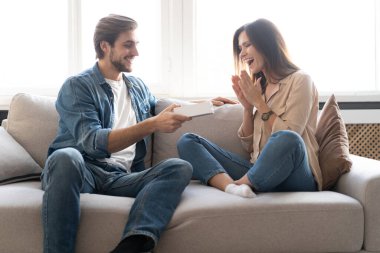 Genç bir kadın evde erkek arkadaşından sürpriz bir hediye kutusu alıyor..