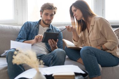 Mali durumlarını belgelerle analiz eden neşeli genç bir çiftin fotoğrafı.