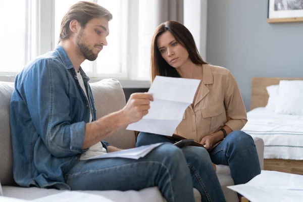 Foto de pareja joven y alegre analizando sus finanzas con documentos — Foto de Stock