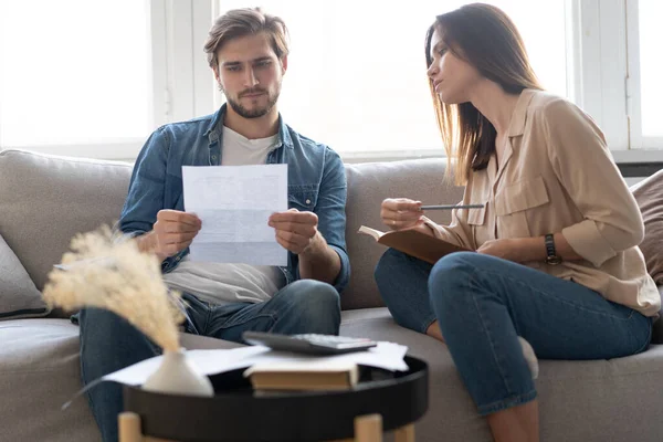 Foto de pareja joven y alegre analizando sus finanzas con documentos — Foto de Stock